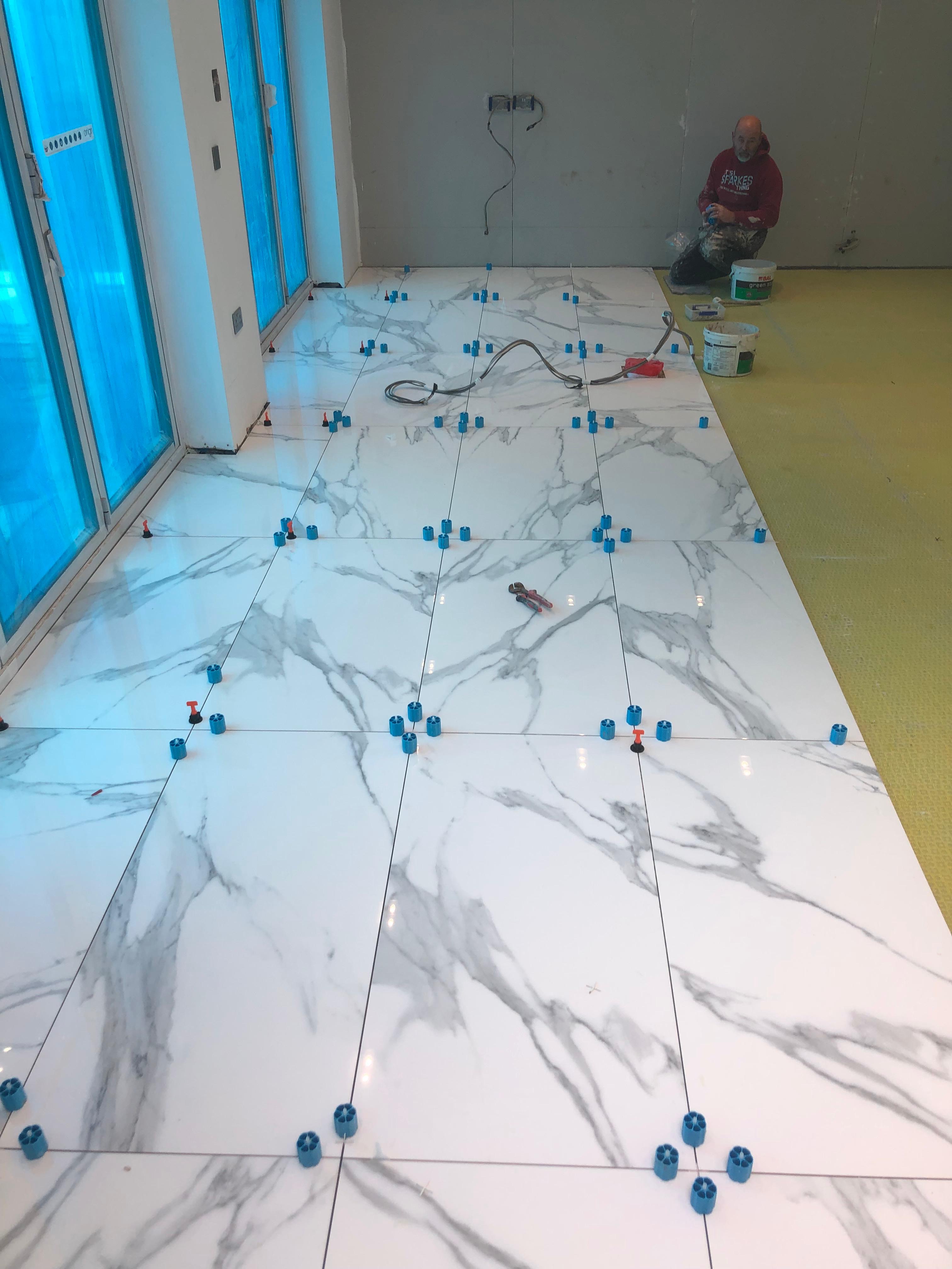 Large Format Tiles in Orpington — Tiler laying large format Calacatta marble floor tiles with levelling clips, Chislehurst — Bromley Tiler